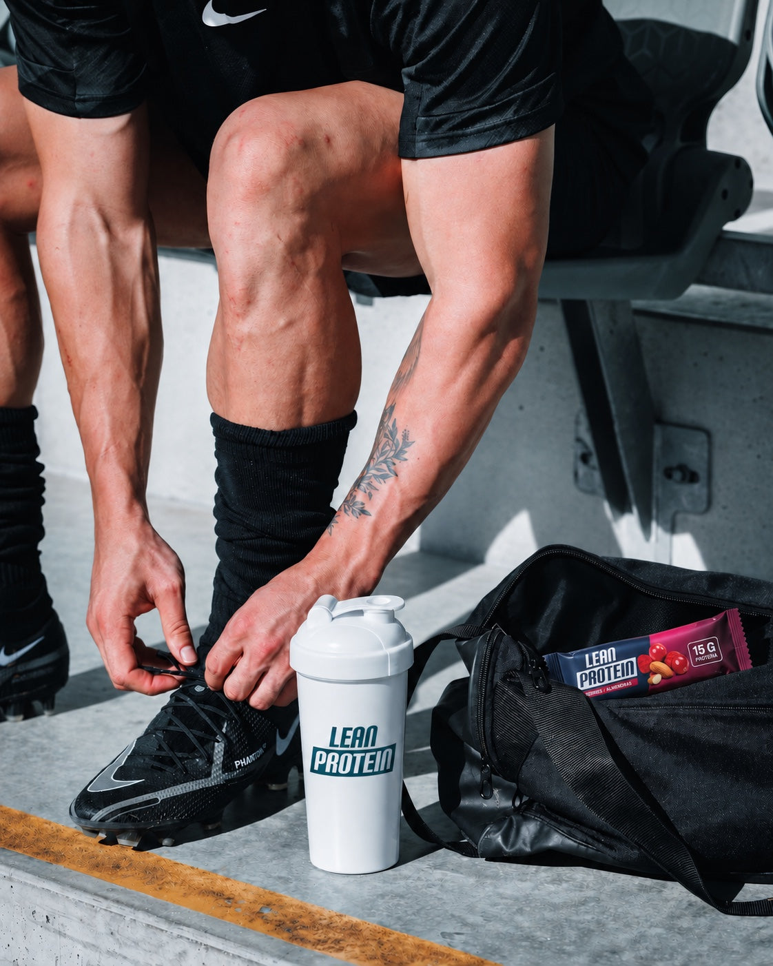 Deportista preparándose junto a un shaker y una barra Lean Protein
