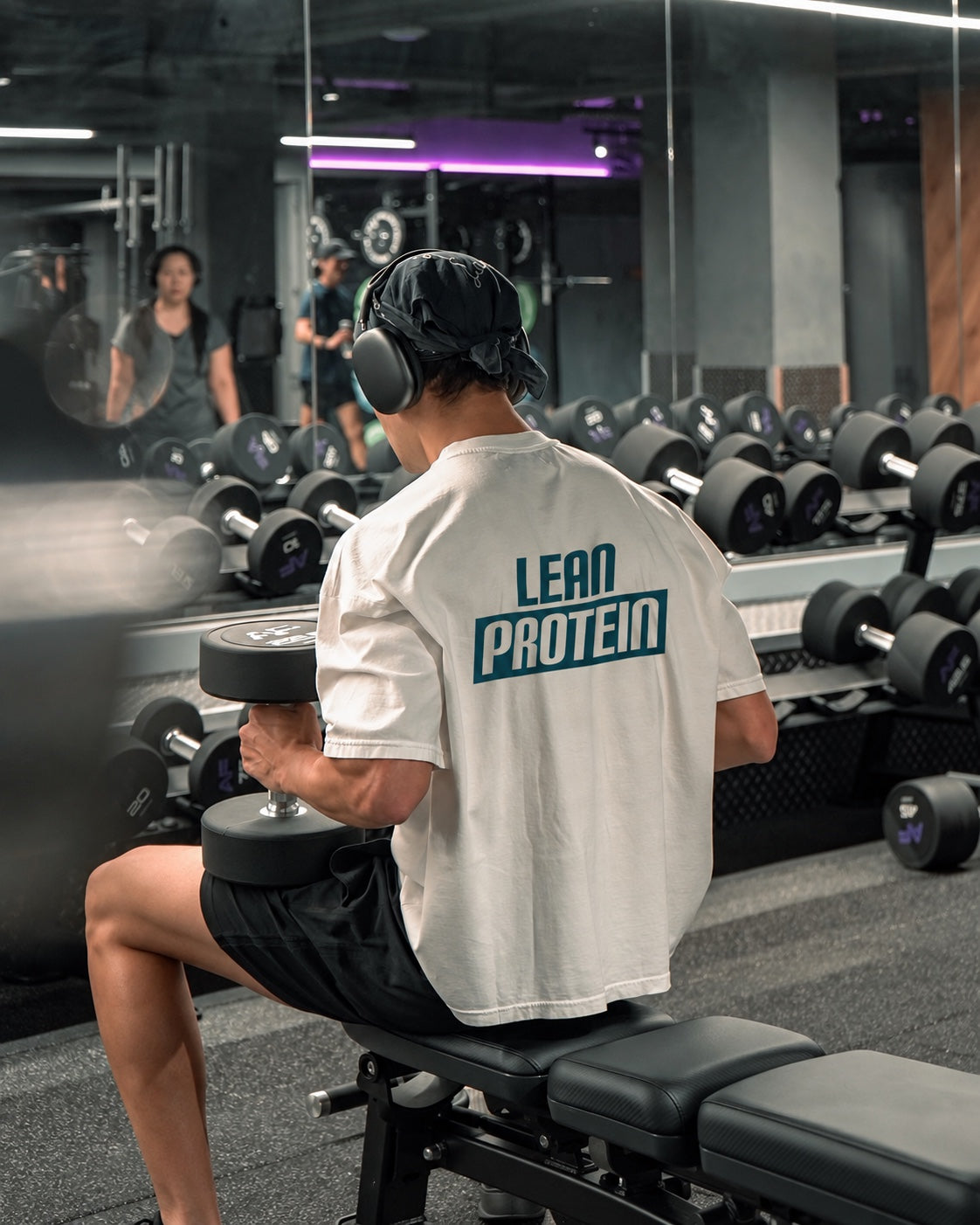 Deportista entrenando con mancuernas y camiseta Lean Protein