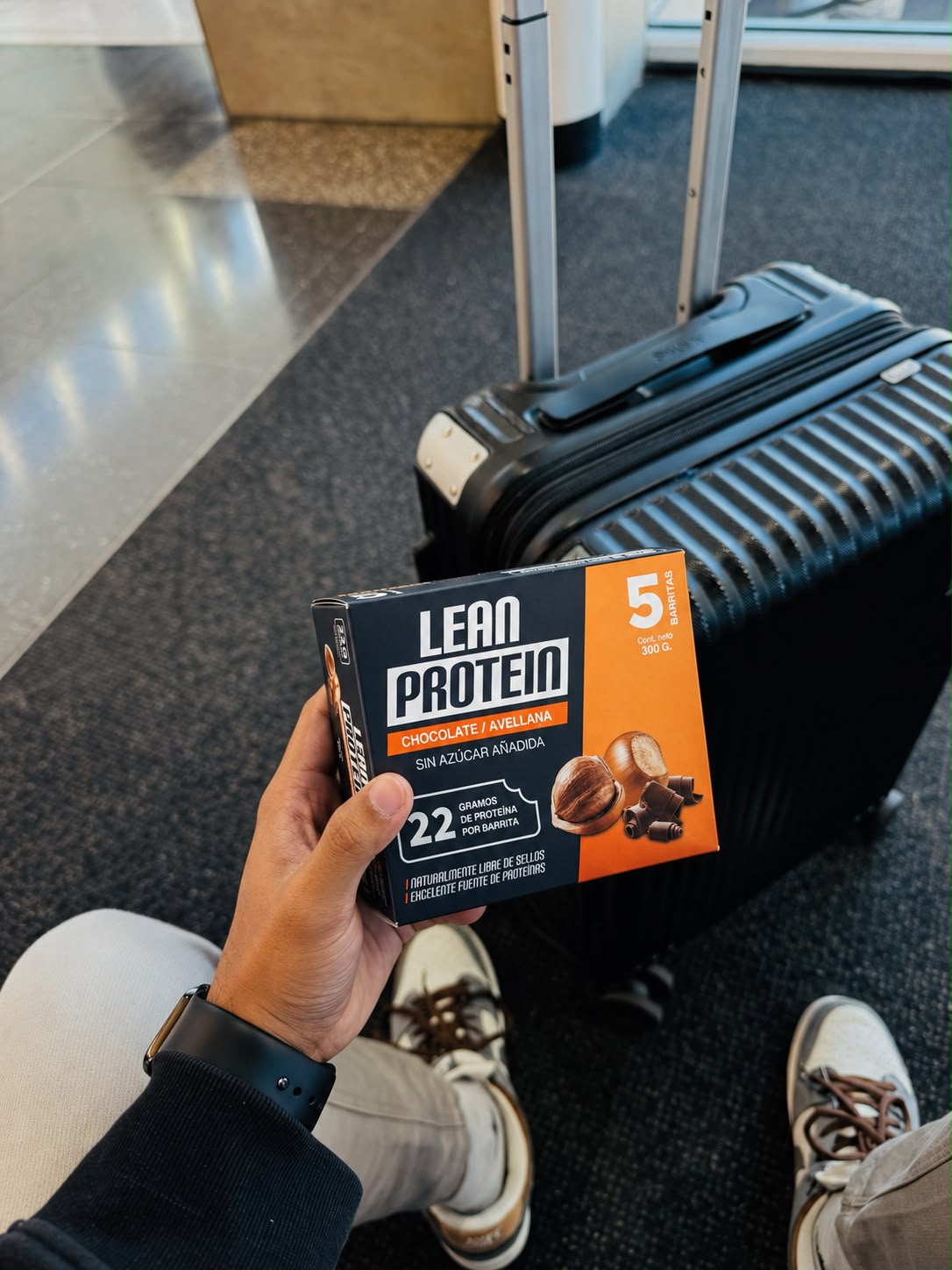 Caja Lean Protein Chocolate y Avellana junto a una maleta
